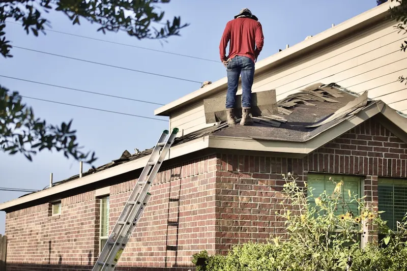 Professional roofer working on a residential roof in Fort Mason
